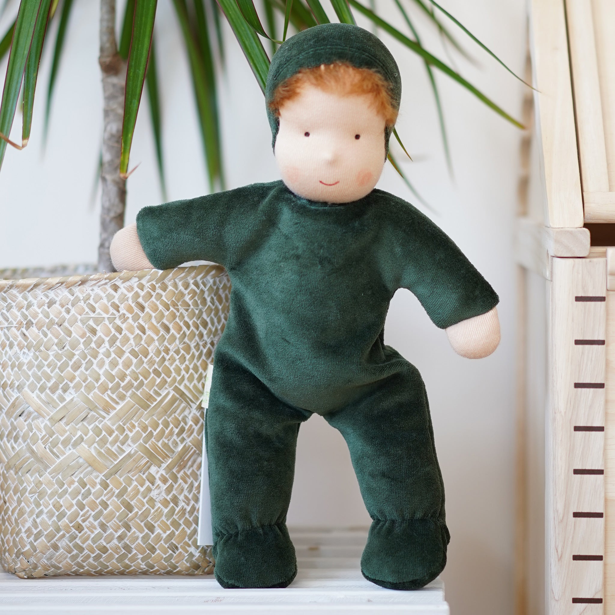 Senger Large Summer Meadow Doll. A velvety forest green natural cloth doll, with a neutral smiling face, light brown hair poking out from the hood, and a soft body, on a cream background.