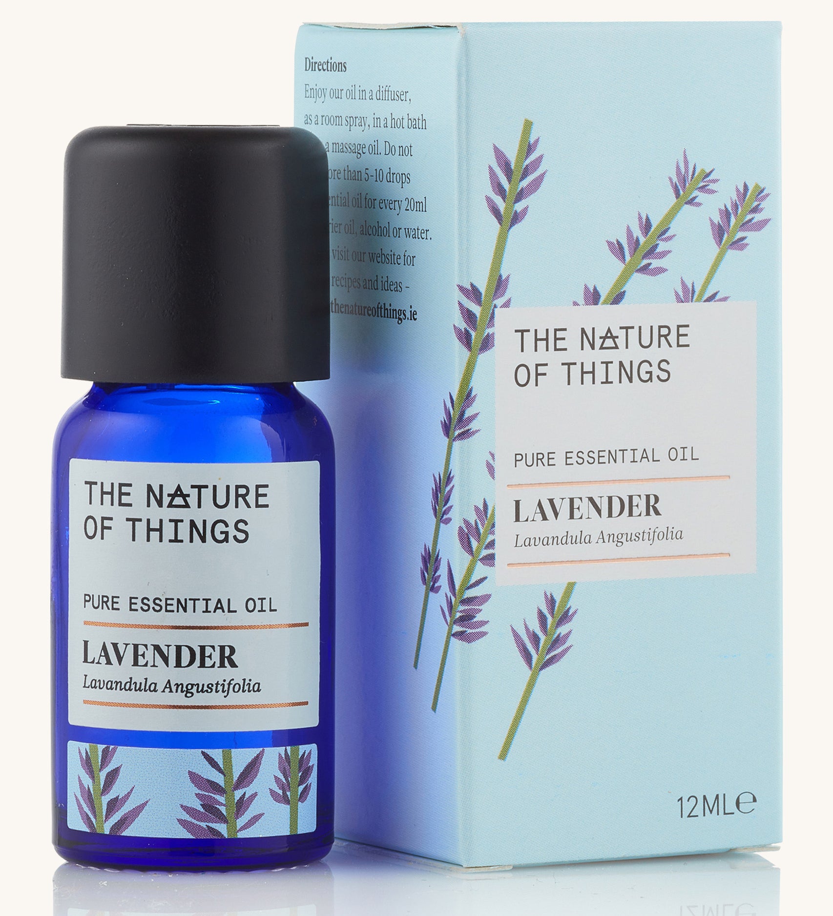 Lavender pure essential oil in a blue glass bottle in front of a decorative blue cardboard box.