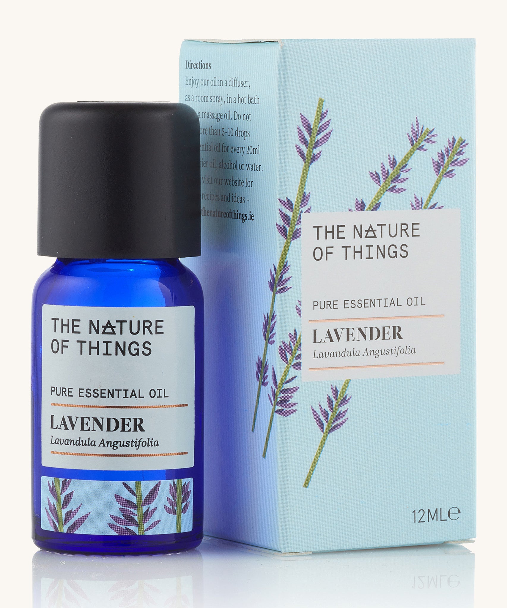 Lavender pure essential oil in a blue glass bottle in front of a decorative blue cardboard box.