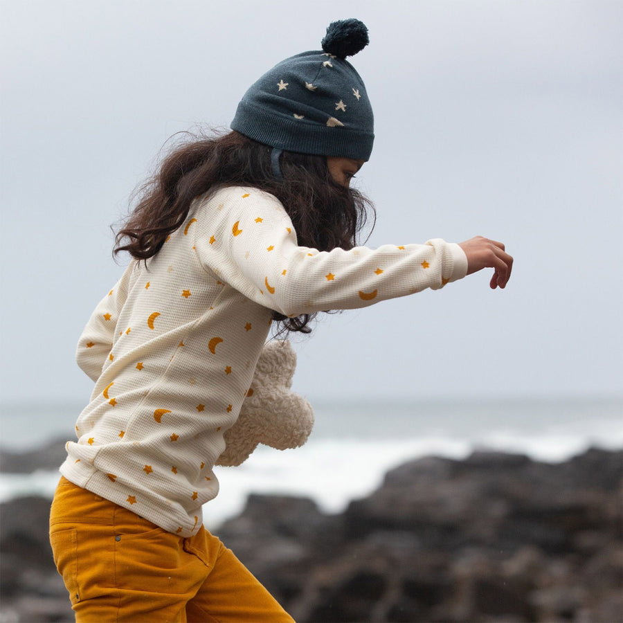 A child wears the LGR Golden Stars Knitted Hat in an outdoor setting.