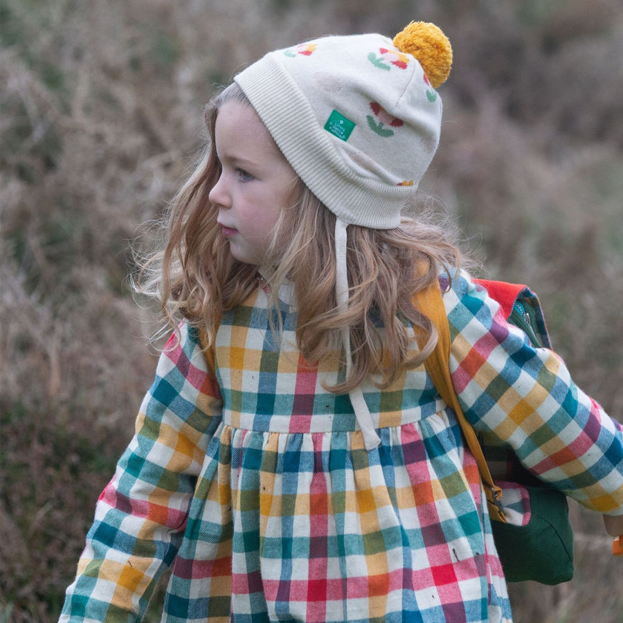 A young child wears the LGR Flower Knitted Hat in an outdoor setting.