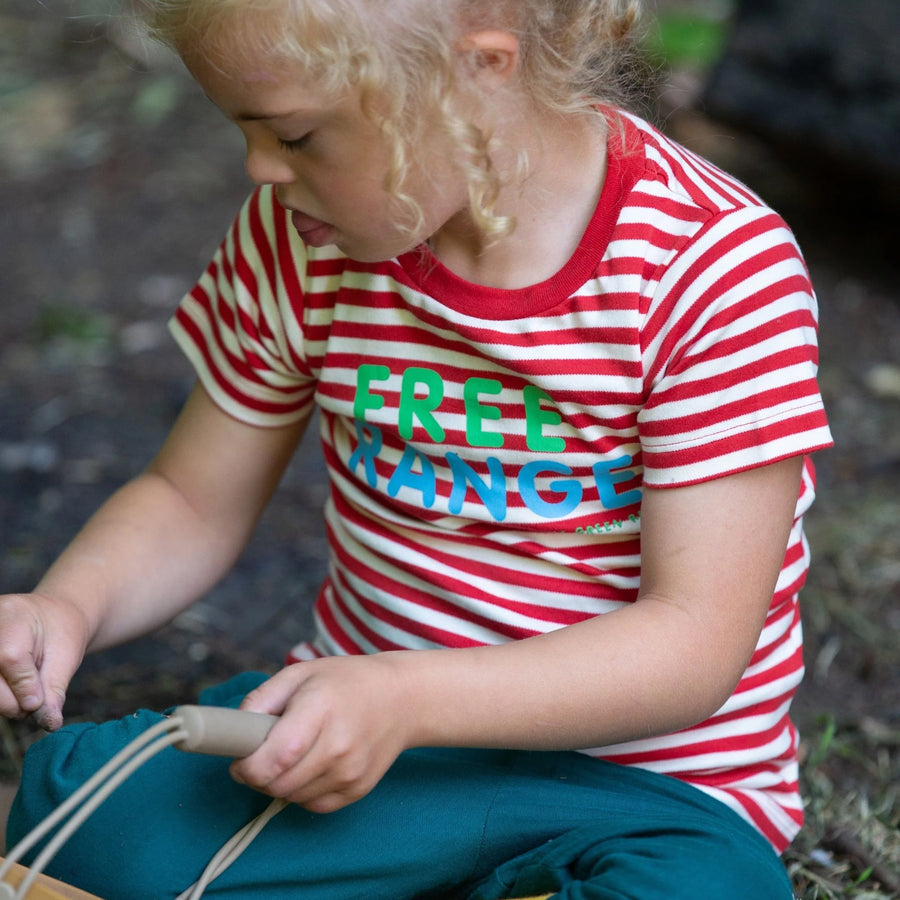 A child playing outside wearing the Little Green Radicals Free Range Top