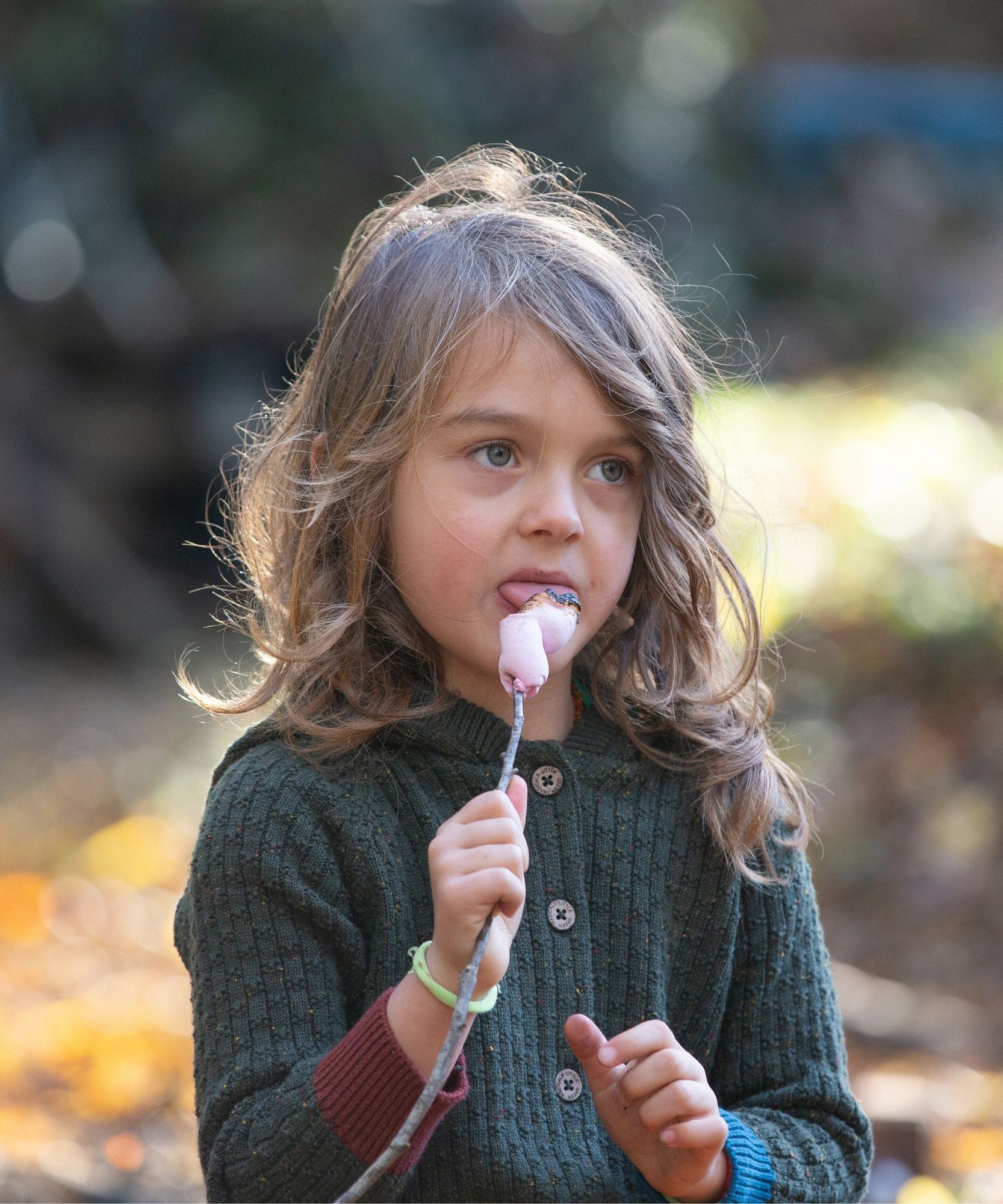 Little Green Radicals kids fern green knitted hooded cardigan with yellow and red pockets worn by a child front button detail