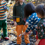 Little Green Radicals kids fern green knitted hooded cardigan with yellow and red pockets worn by a child