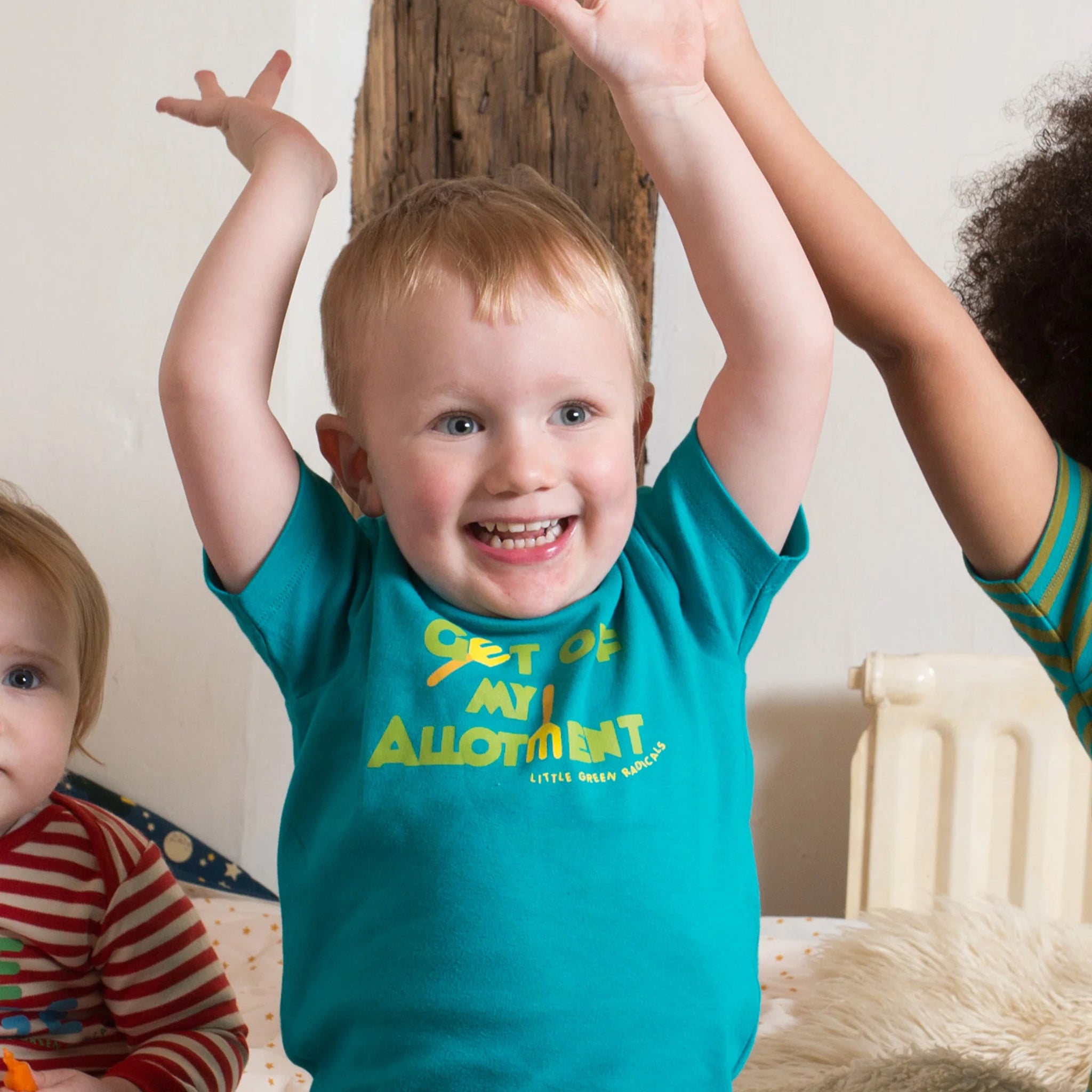 A child happily playing whilst wearing the Little Green Radicals Allotment Top