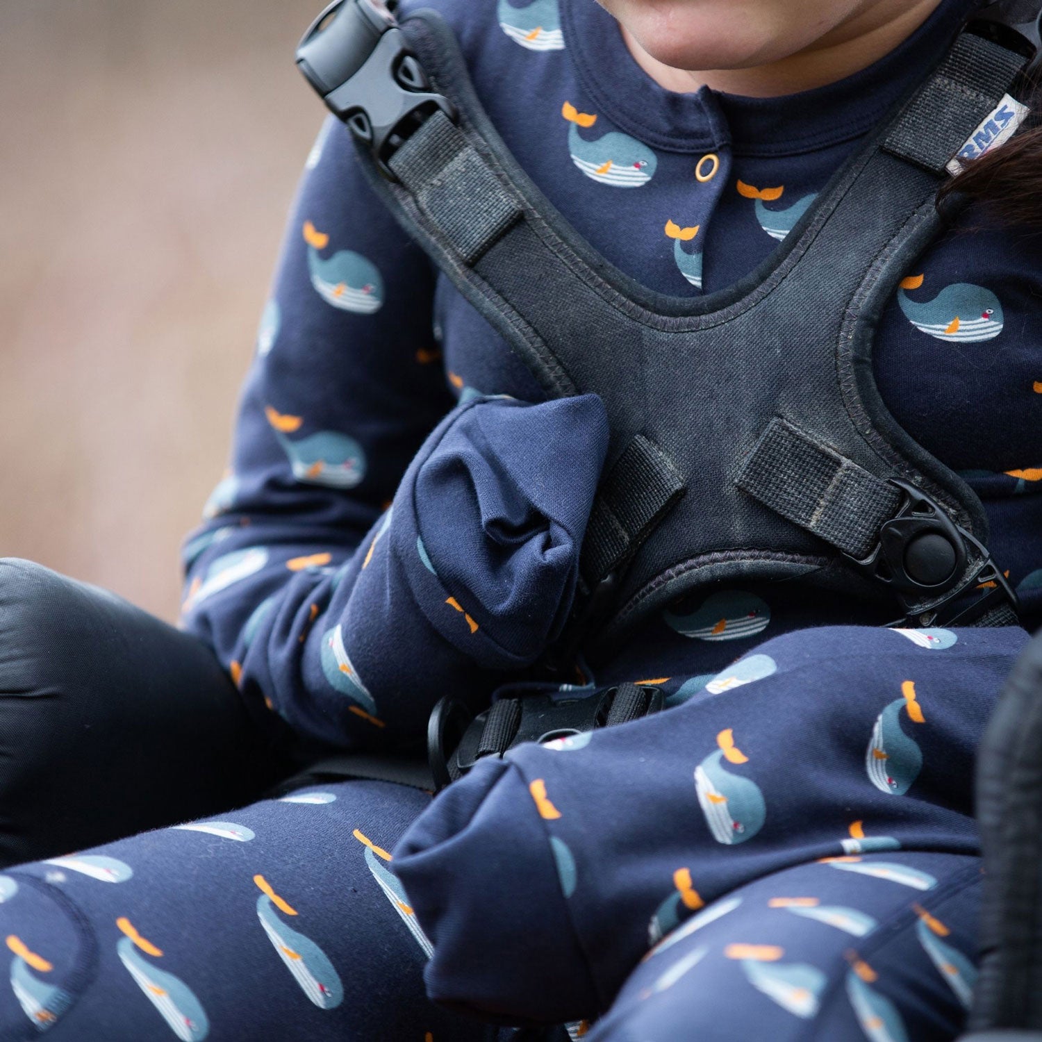 Child wearing the Little Green Radicals Adaptive Whale Song Sleepsuit