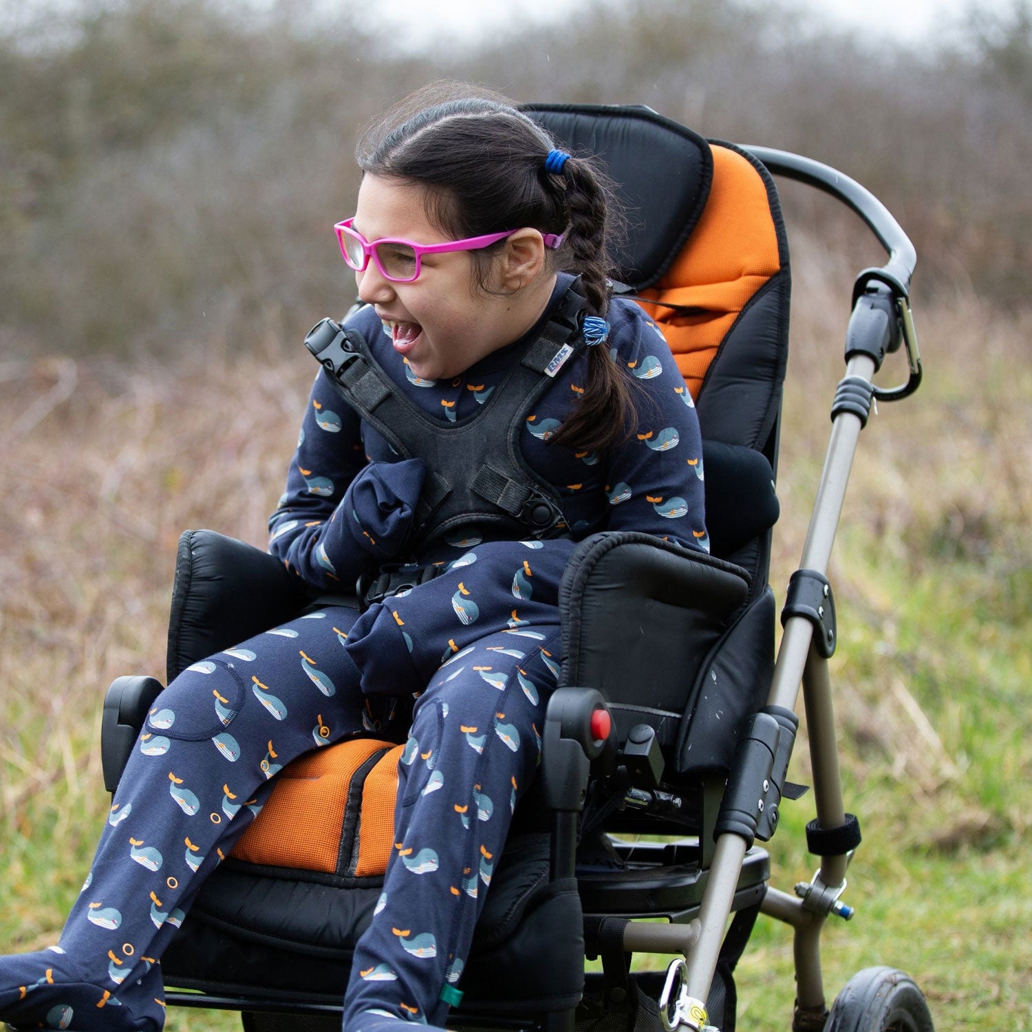 Child wearing the Little Green Radicals Adaptive Whale Song Sleepsuit