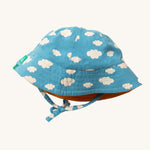 Little Green Radicals organic cotton Blue Clouds Reversible Baby Sun Hat, shown with the cloud print on the outside.