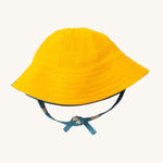 Little Green Radicals organic cotton Blue Clouds Reversible Baby Sun Hat, shown with the plain yellow side on the outside.