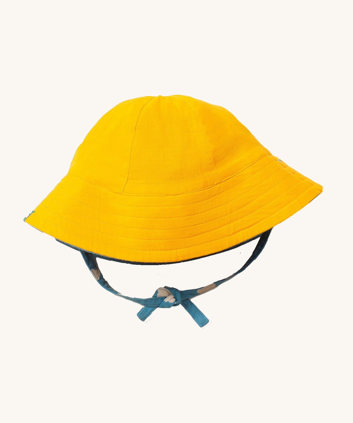 Little Green Radicals organic cotton Blue Clouds Reversible Baby Sun Hat, shown with the plain yellow side on the outside.