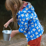 A side view of a child wearing the Little Green Radicals Diving And Splashing Blue Recycled Waterproof Kids Packable Anorak