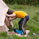 A child wearing the Little Green Radicals Navy Rainbow Stripe Organic Comfy Joggers with a yellow short sleeved t-shirt.