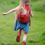 A child running wearing the Little Green Radicals Kids Ready For Adventure Yellow Stars print red and green Backpack on their back. The child is facing away from the camera giving a full view of the backpack