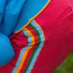 A close up of the rainbow coloured stripes on the side of the Little Green Radicals children's Red Comfy Jogger Shorts.