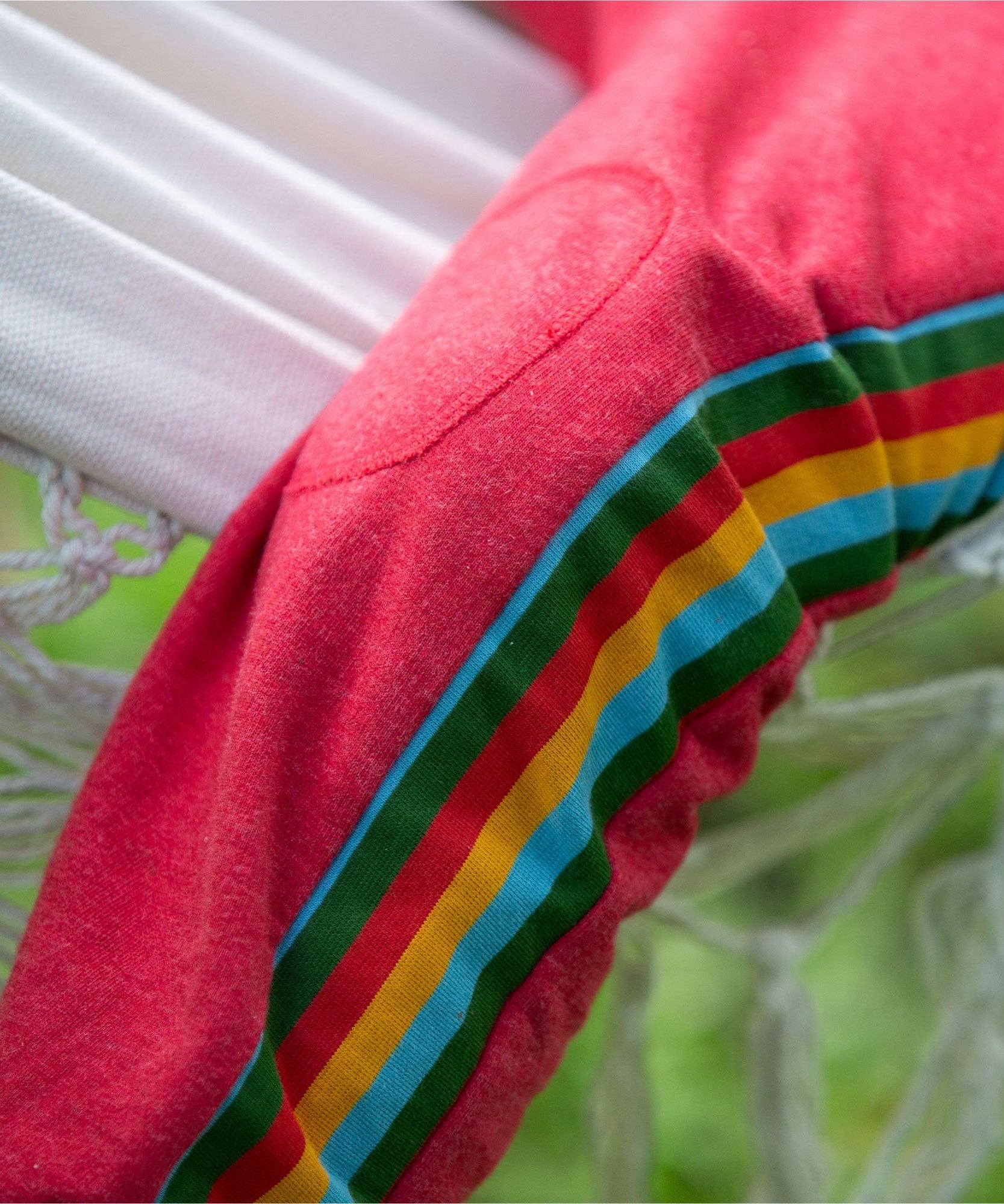 A close up of the stripe detail on the side of the Little Green Radicals Red Organic Cotton Comfy Joggers with rainbow stripe on the sides.