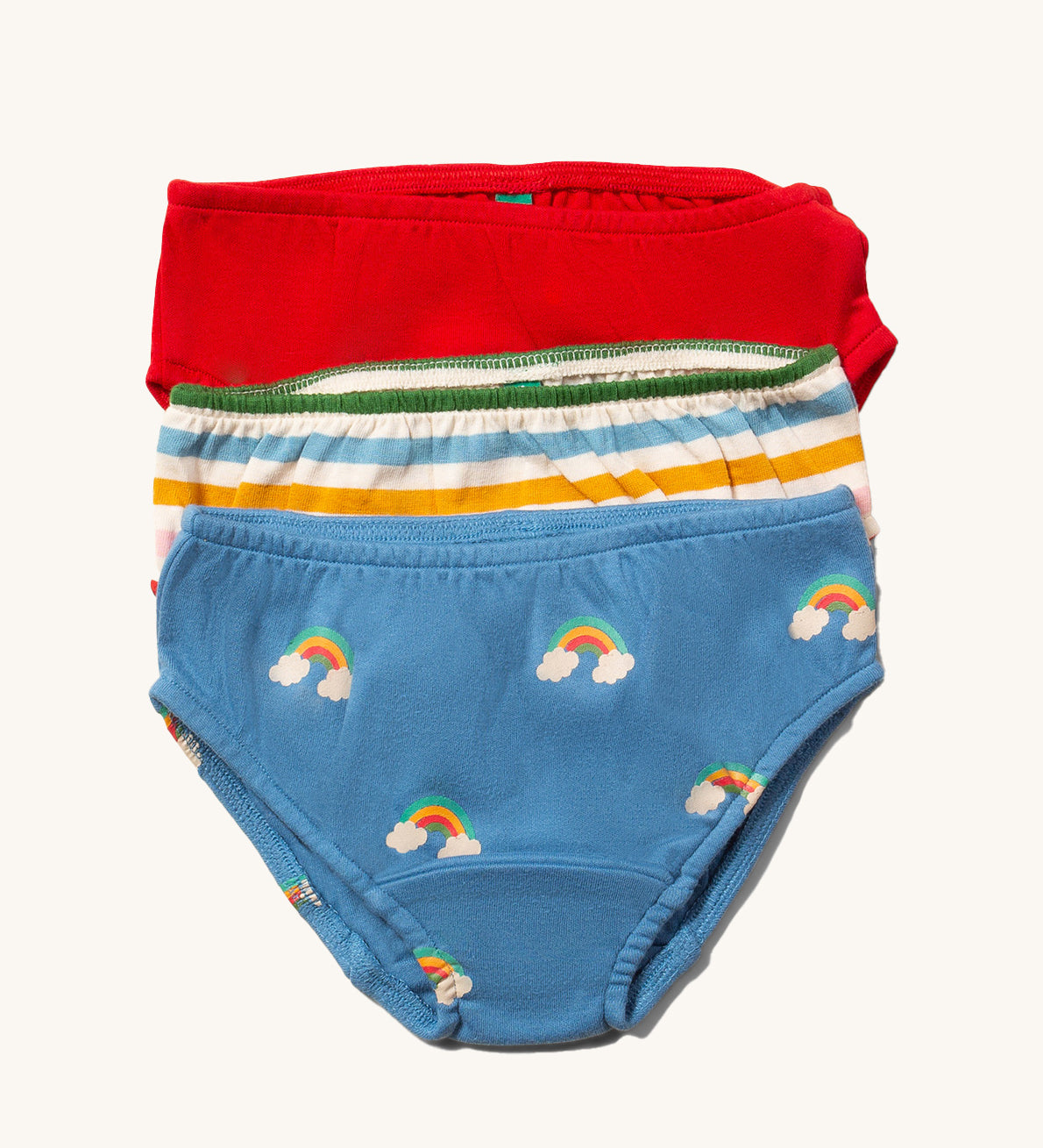 Little Green Radicals Organic Cotton Underwear Briefs Set in a 3 pack. One pair has a rainbow print on a blue background, one has multi coloured stripes and one is plain red.