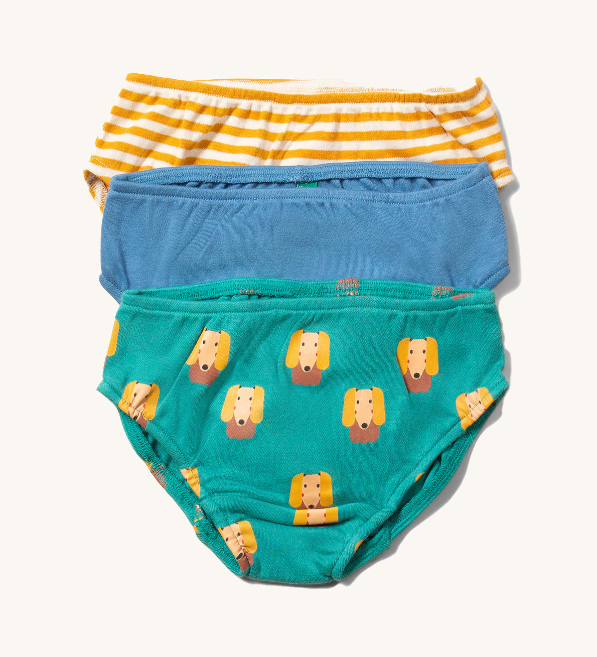 Little Green Radicals Organic Cotton Underwear Briefs Set in a 3 pack. One pair has a little dog print on a green background, one has yellow gold stripes and one is plain blue.