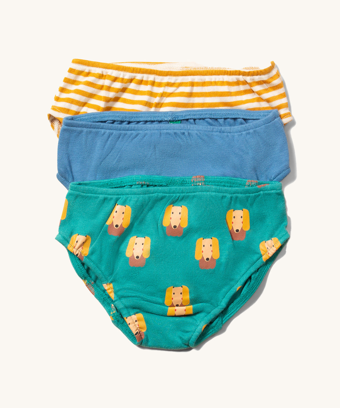 Little Green Radicals Organic Cotton Underwear Briefs Set in a 3 pack. One pair has a little dog print on a green background, one has yellow gold stripes and one is plain blue.