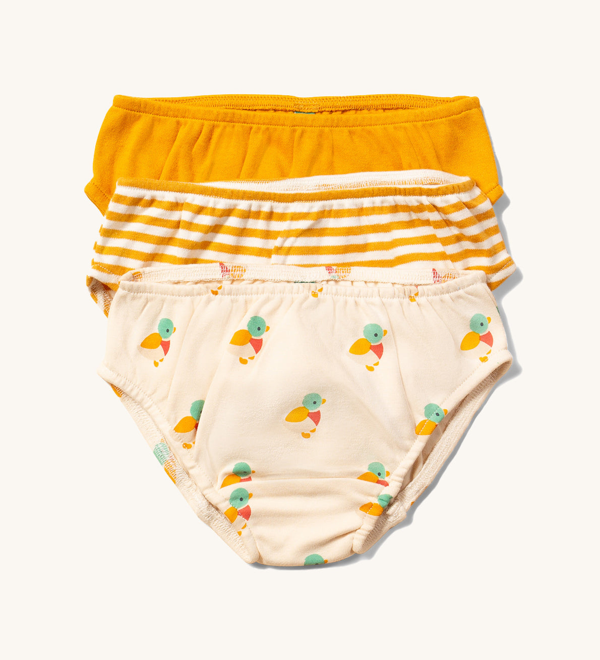 Little Green Radicals Organic Cotton Underwear Briefs Set in a 3 pack. One pair has a little duck print on a cream background, one has yellow gold stripes and one is plain yellow gold.