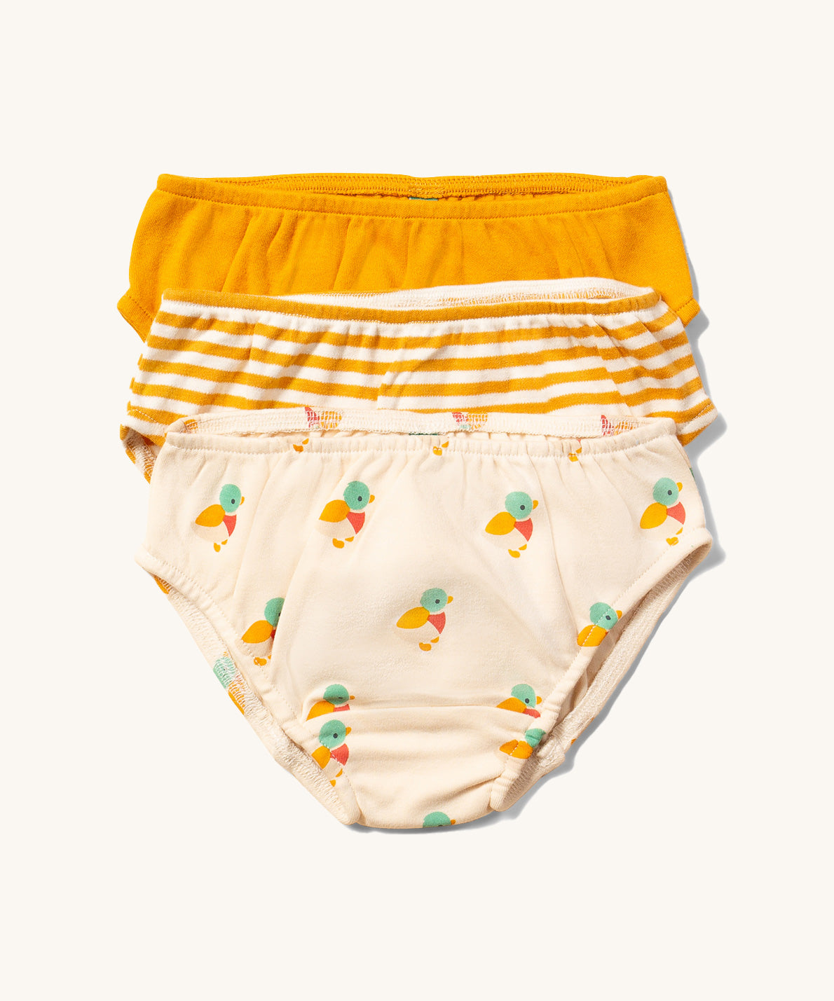 Little Green Radicals Organic Cotton Underwear Briefs Set in a 3 pack. One pair has a little duck print on a cream background, one has yellow gold stripes and one is plain yellow gold.