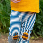 A close up of a child's legs wearing the Little Green Radicals Bees Knees Patch Striped blue and white Joggers