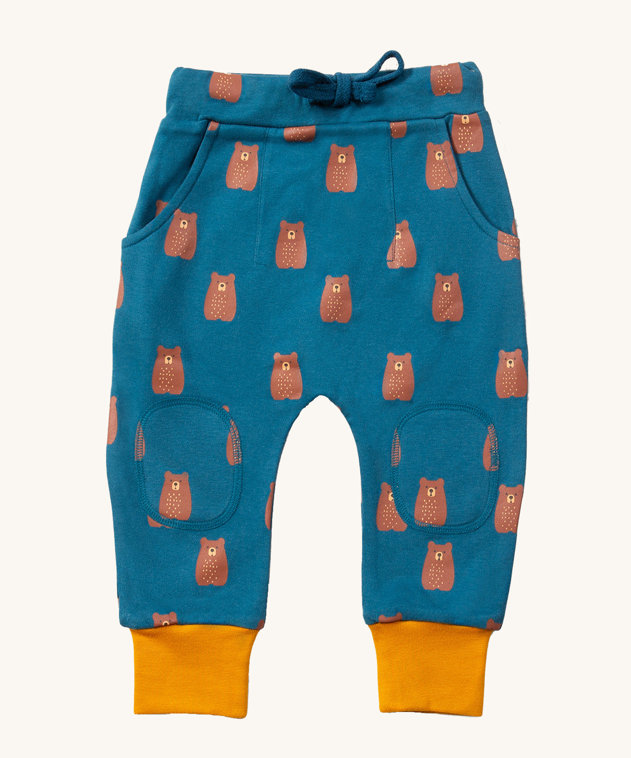 Little Green Radicals Organic Cotton Kids Comfy Joggers with a brown Teddy Bears print on a blue coloured background. The joggers have yellow gold coloured cuffs.