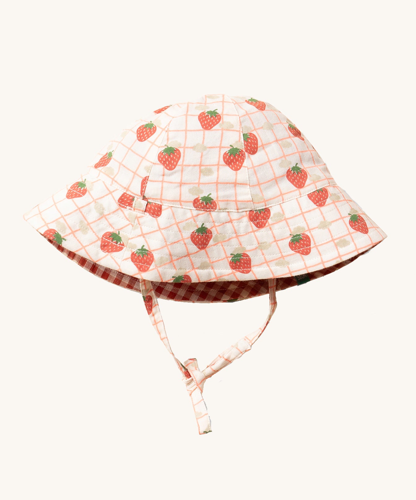 Little Green Radicals Strawberry Days Reversible Kids Sun Hat. The side with the strawberry print on a cream background is shown.