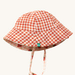 Little Green Radicals Strawberry Days Reversible Kids Sun Hat. The side with the red and cream gingham is shown.