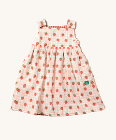 Little Green Radicals Child's Organic Cotton Strawberry Days Reversible Pinny Dress shown with the strawberry print on the outside.