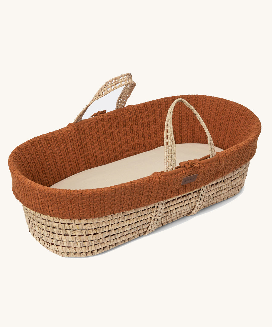 Little Green Sheep Organic Knitted Moses Basket & Mattress in terracotta pictured on a plain background