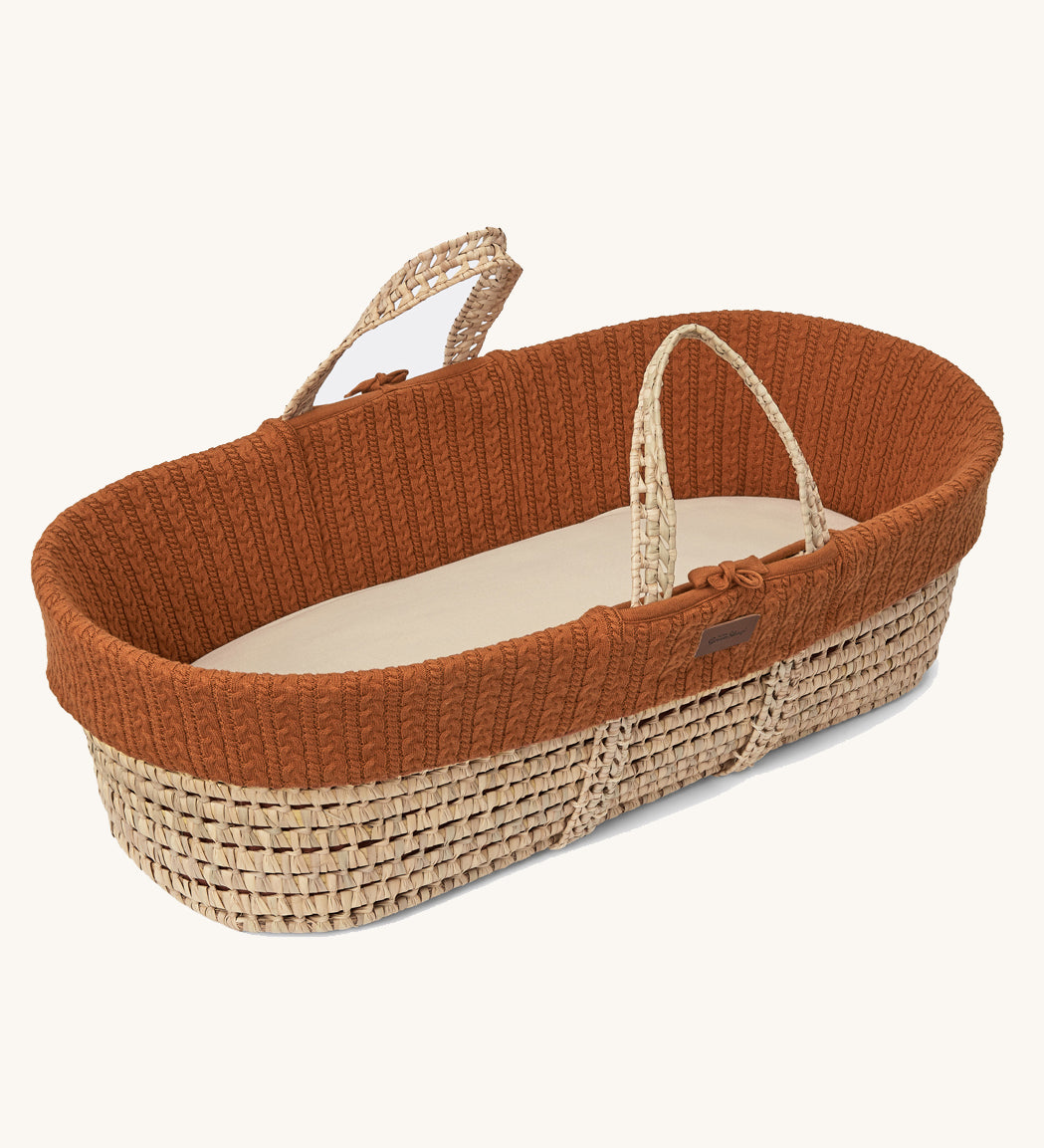 Little Green Sheep Organic Knitted Moses Basket & Mattress in terracotta pictured on a plain background