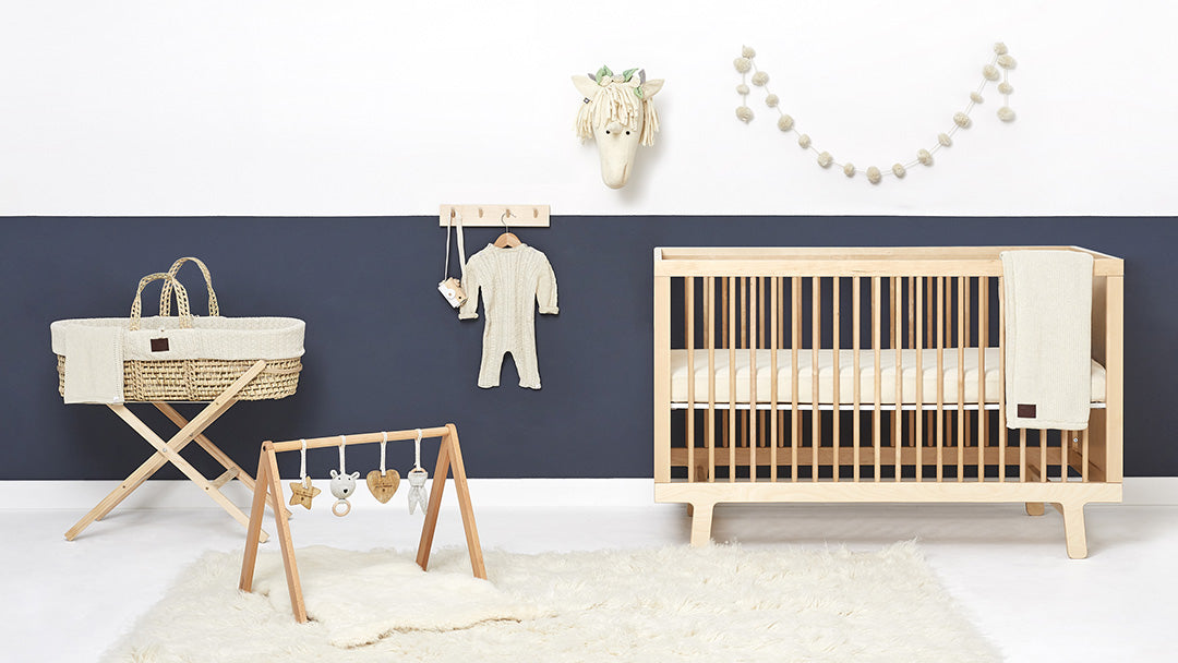 A child's bedroom containing Little green Sheep furniture such as a Moses Basket, a Cot, and mattresses