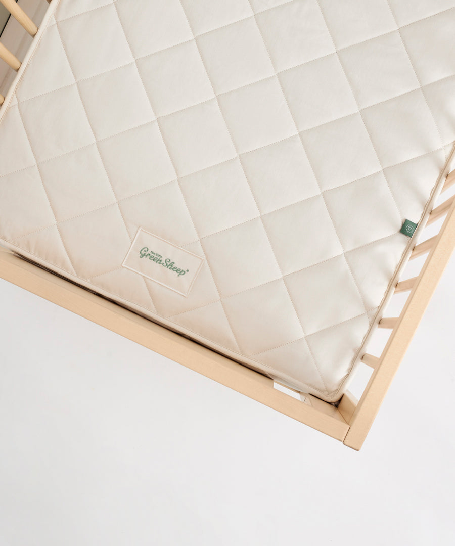 Little Green Sheep Twist Natural SnuzKot Mattress pictured in a wooden cot