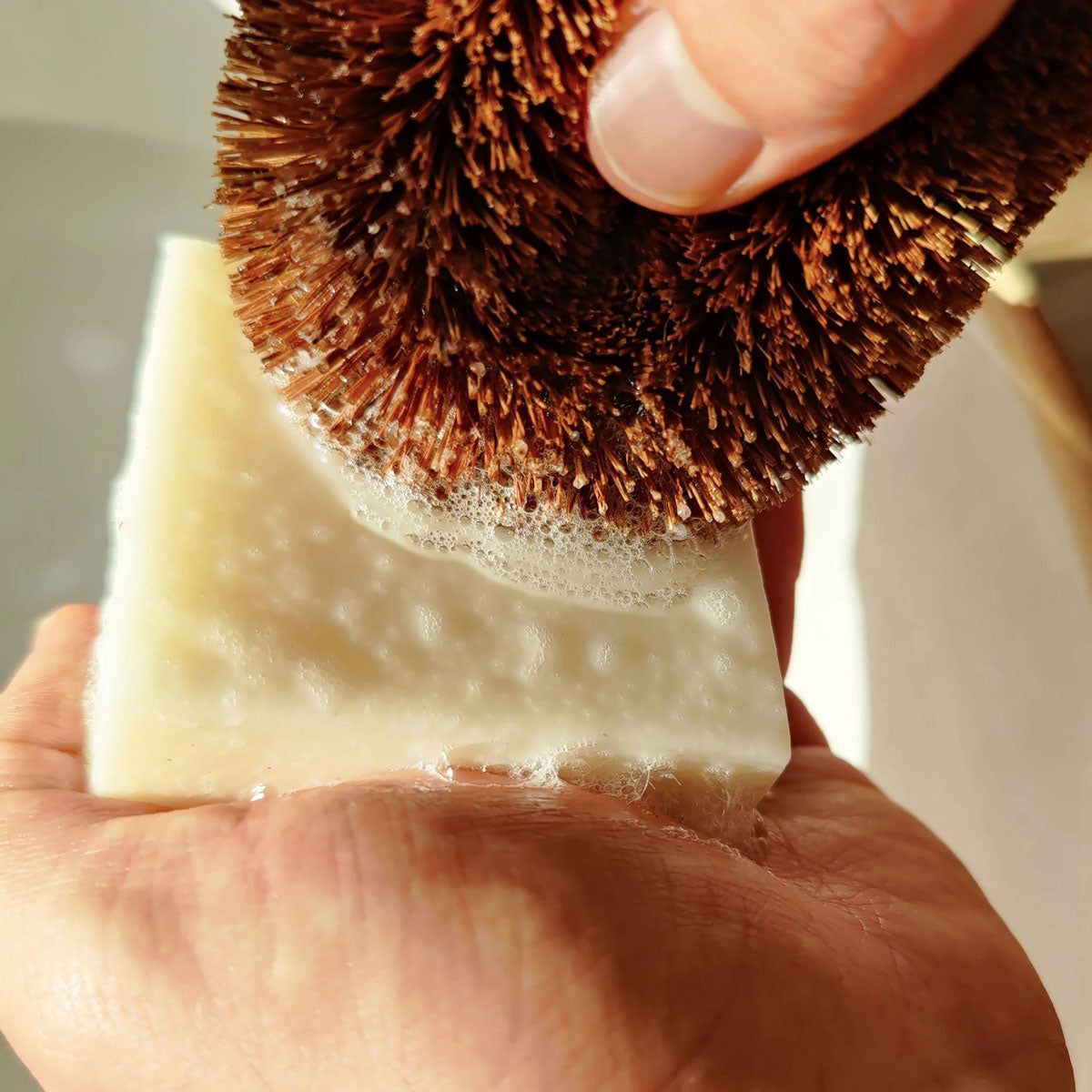 Person using a LoofCo Lime scented Washing-Up Dish Soap Bar with a coconut dish brush