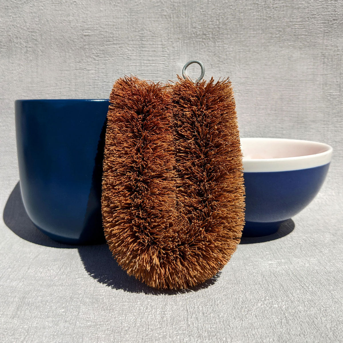 loofco washing-up brush pictured in front of a blue cup and bowl