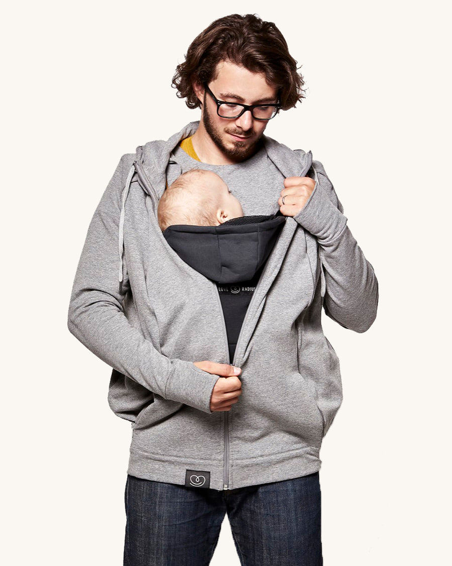 An adult wearing the Love Radius Parents Hoodie In Heather Grey, with a child inside showing the wrap-over chest cover. On a cream background