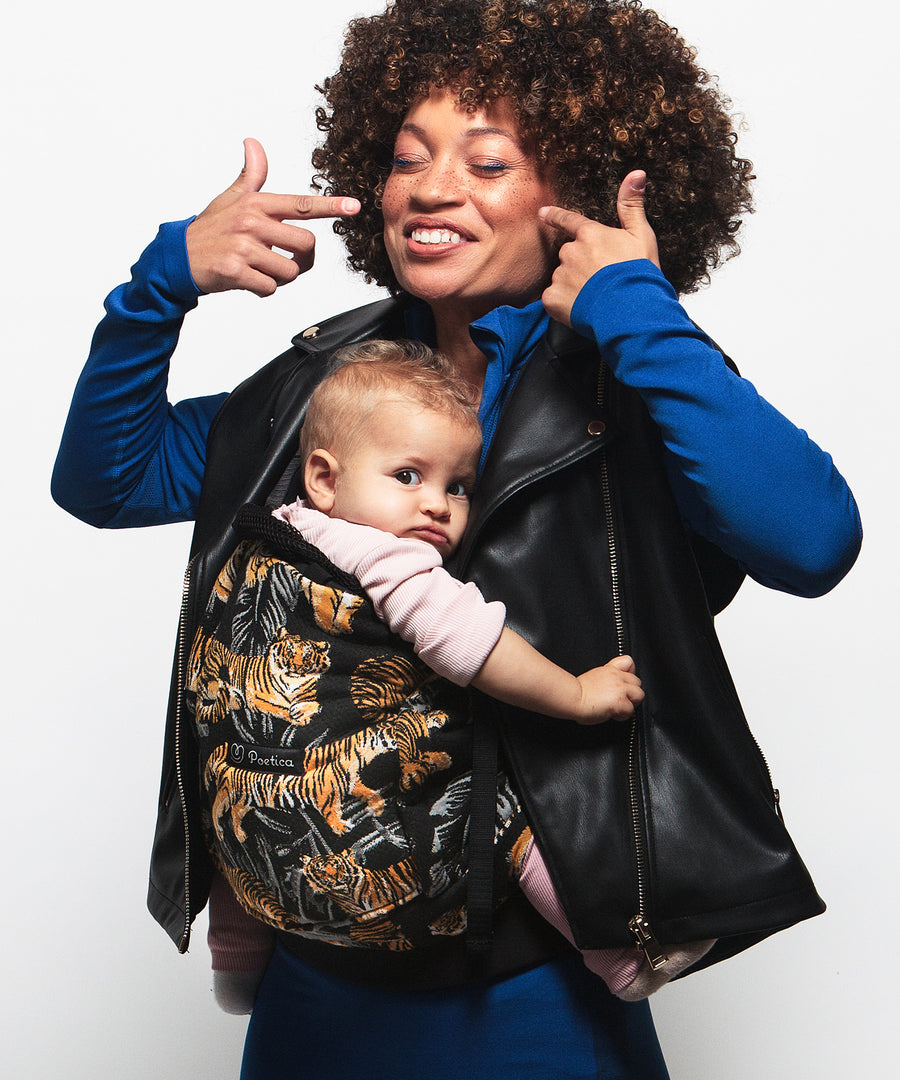 An adult carrying a baby in the Love Radius PhysioCarrier in Tiger.