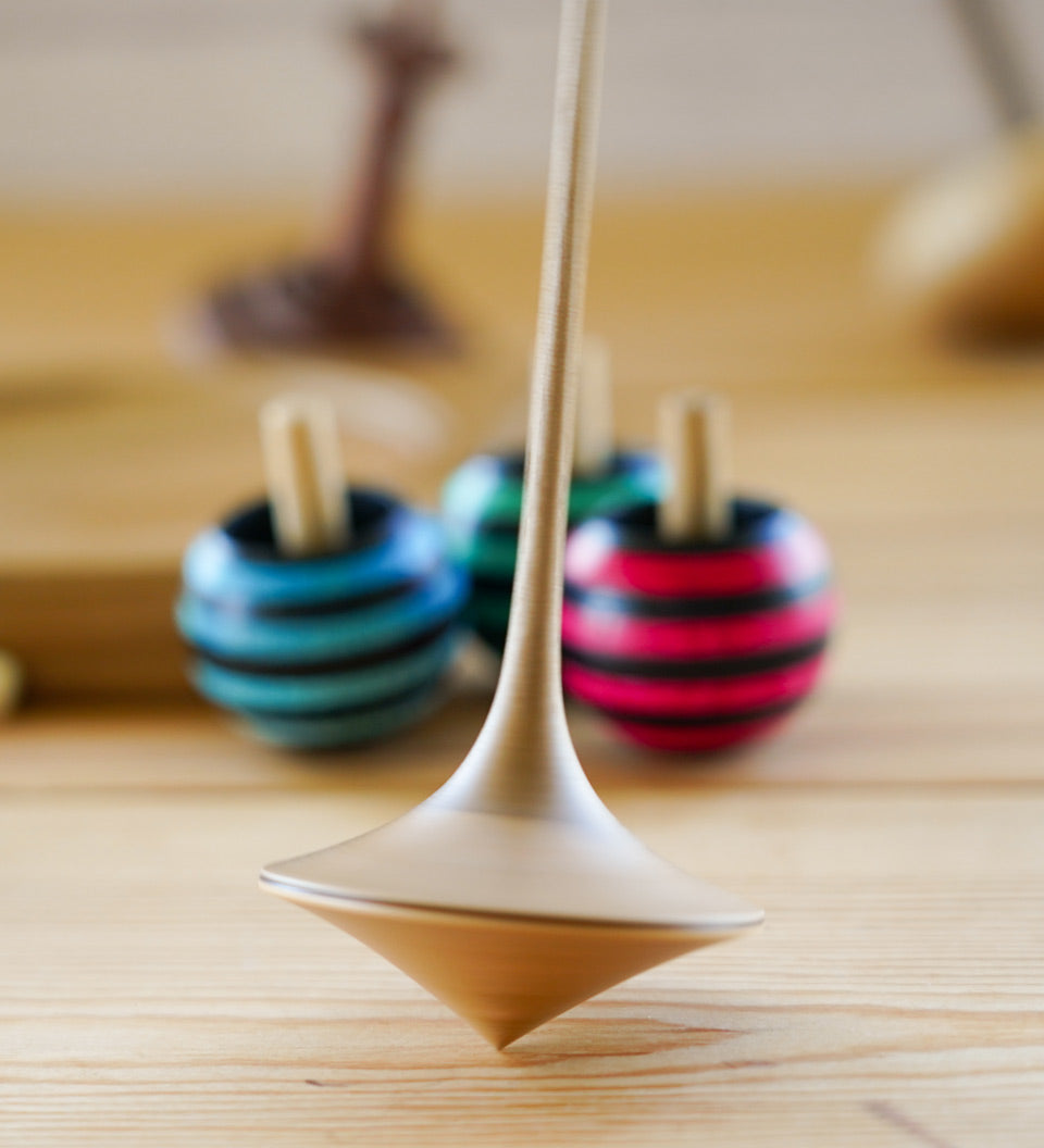 Mader hand carved ballerina spinning top toy on a wooden background