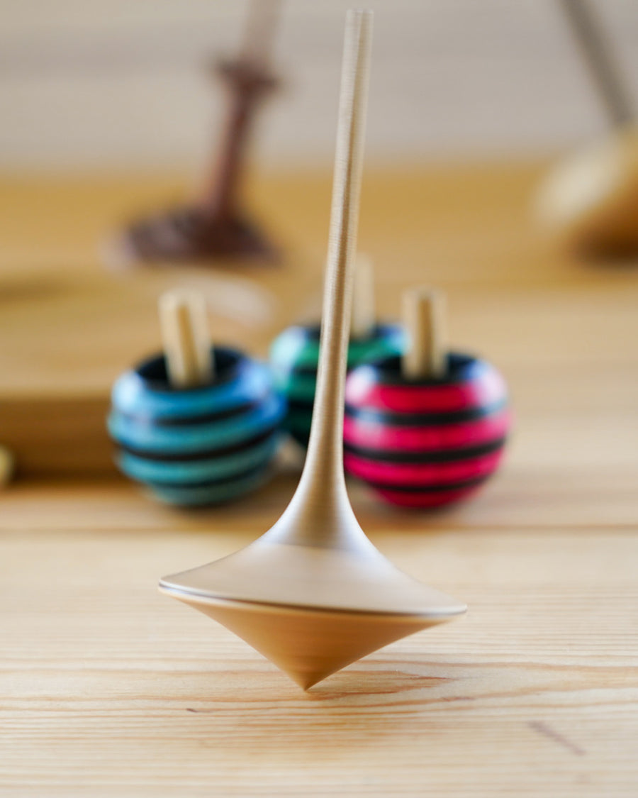 Mader hand carved ballerina spinning top toy on a wooden background