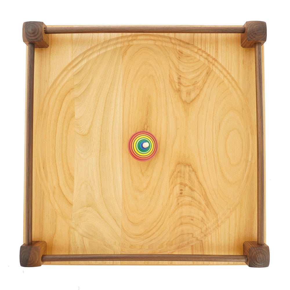 Top view of a rainbow spinning top on the Mader 40cm large Manege Spinning Plate on a white background