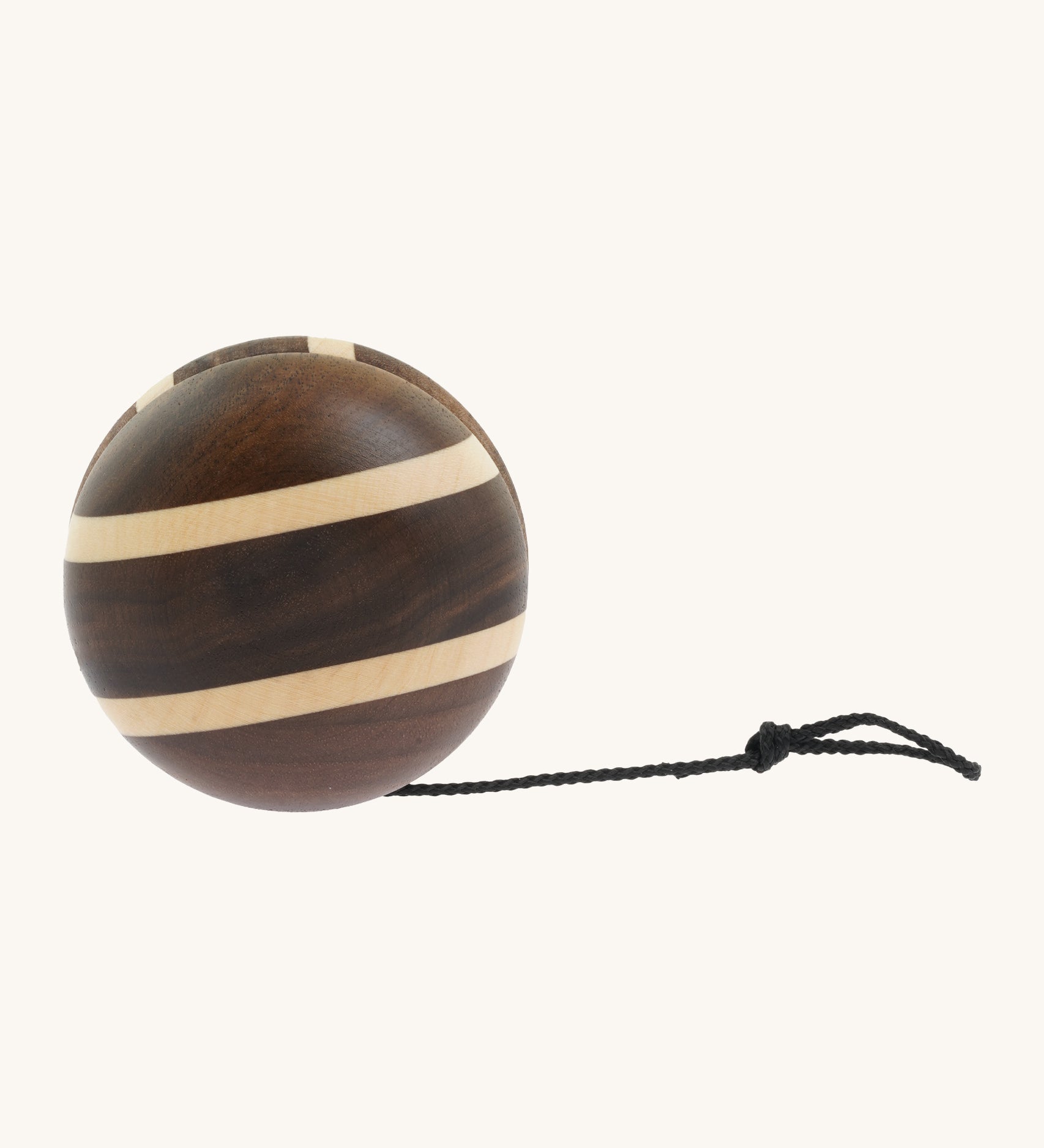 A natural wooden Mader yo yo with black string and different woods, showcasing the unique grains and colours of the natural wood on a cream background.