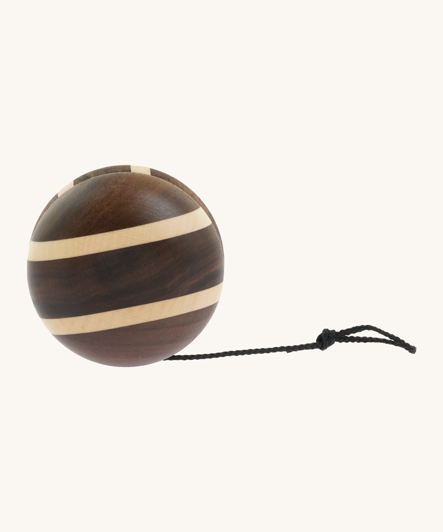 A natural wooden Mader yo yo with black string and different woods, showcasing the unique grains and colours of the natural wood on a cream background.