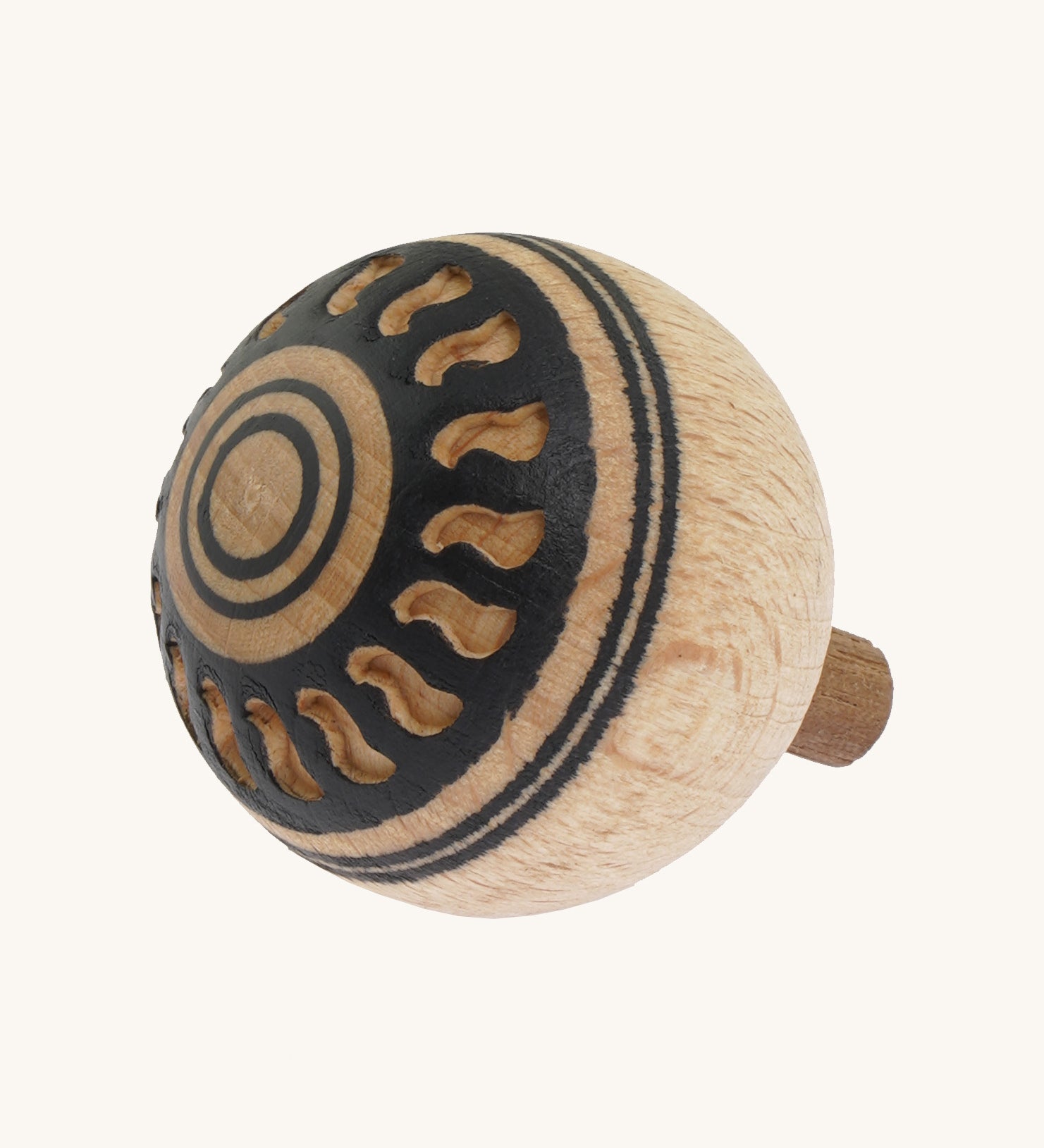 A wooden Mader Oriental turn over spinning top with a cut out pattern design on the bottom on a cream background.