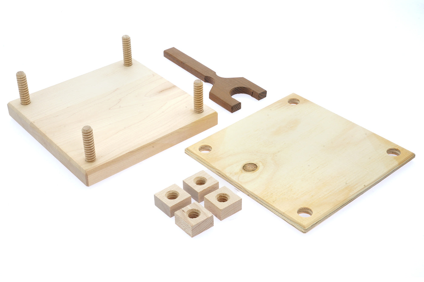 Pieces of the Mader plastic-free carved wooden flower press kit laid out on a white background