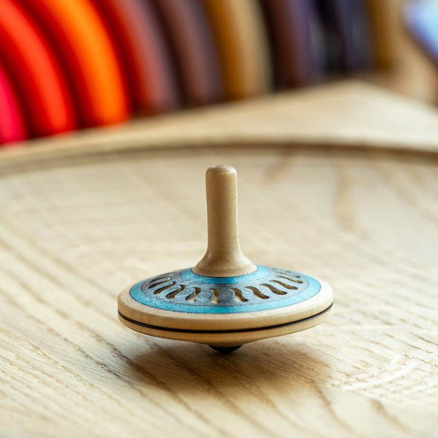 Mader Arabesk Finger Spinning Top sits on a spinning plate.