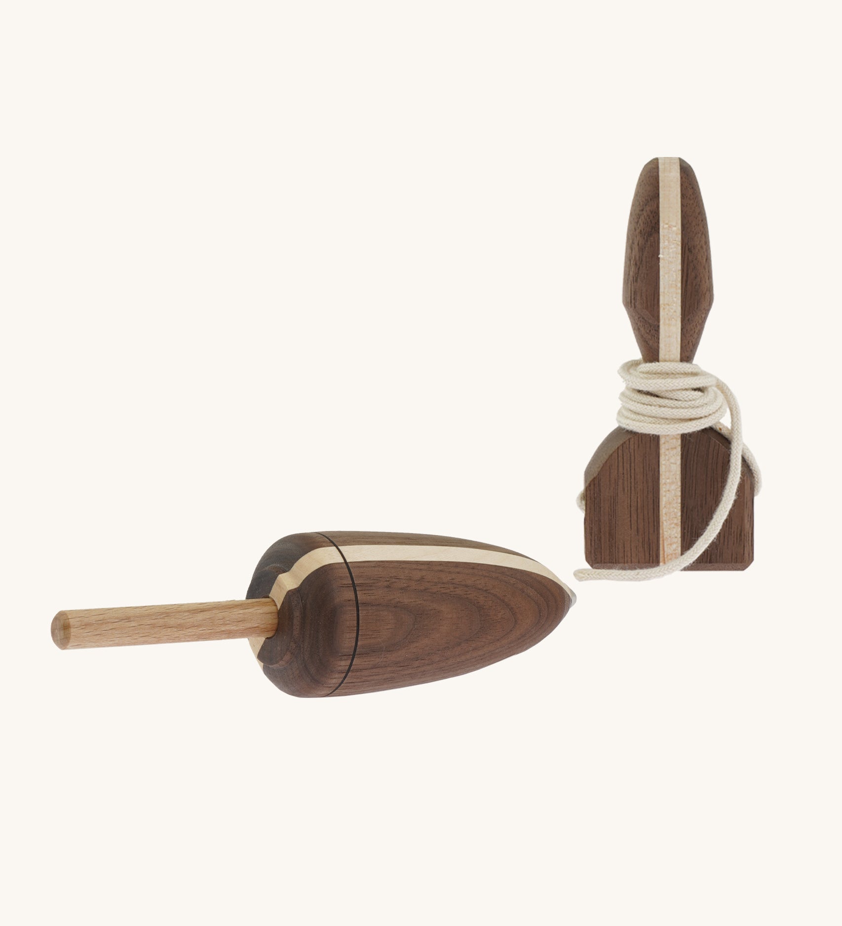 A wooden Mader Goliath spinning top with a light wood strip through the middle with a matching wooden starter on a cream background.