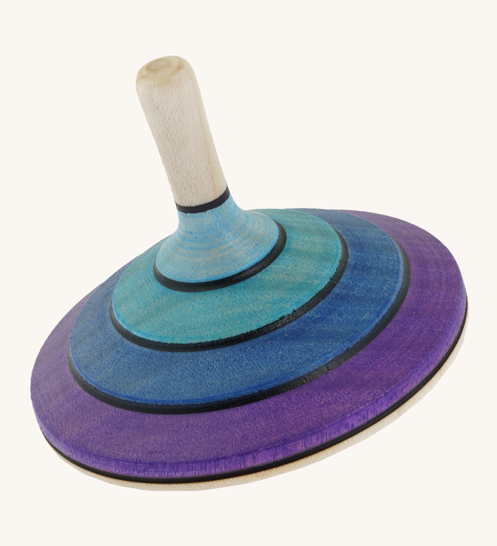 A wooden purple and blue flamenco Mader spinning top on a cream background.