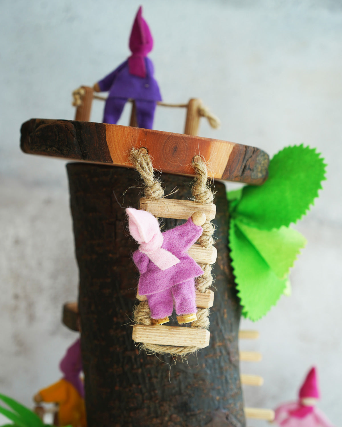 Magic Wood pose-able felt elves with the log cabin. one is stood at the top