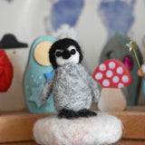 A small felted penquin figure created using The Makerss  Amiguwoolli Penguin Mini Needle Felt Kit. 