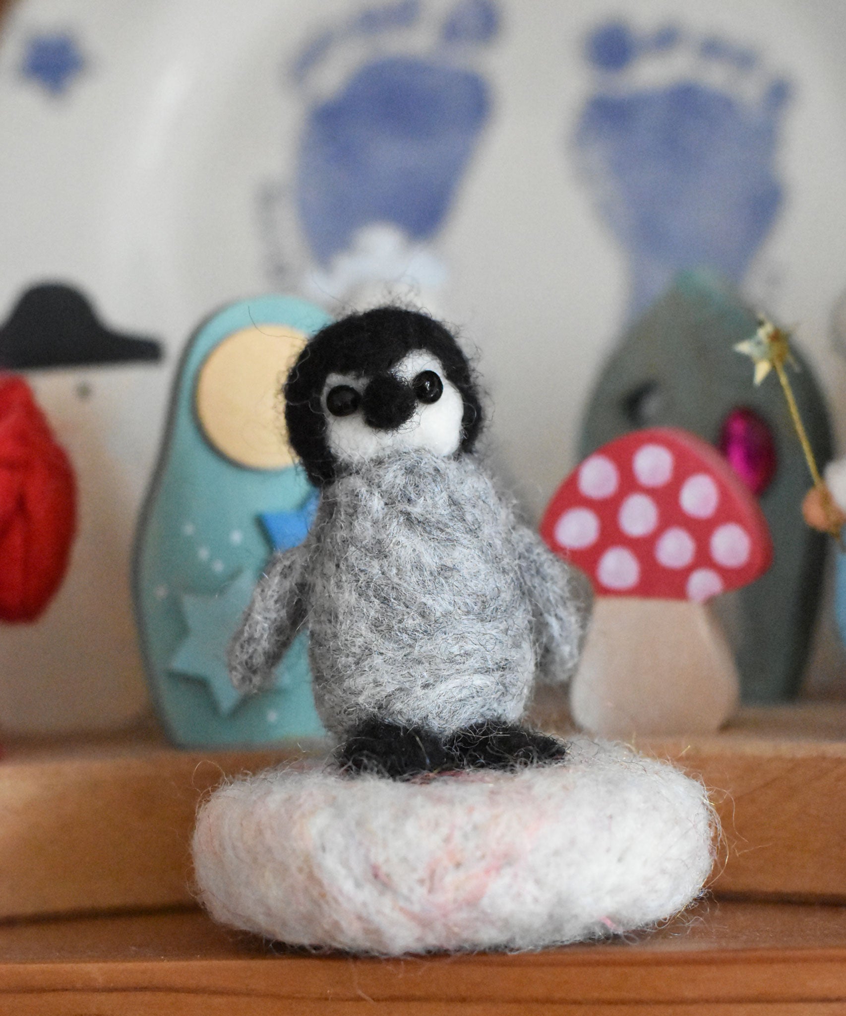 A small felted penquin figure created using The Makerss  Amiguwoolli Penguin Mini Needle Felt Kit. 